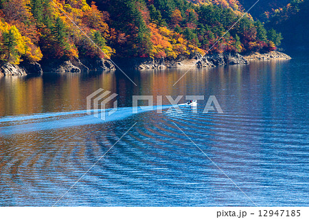 新潟県魚沼市 奥只見湖 紅葉の釣り船の写真素材