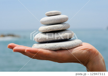 Gravel pile in woman's hands with sea background 12947311
