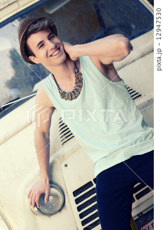 Young handsome man with an old van wearing sun hat Young handsome man with an old van wearing sun hat 12947530
