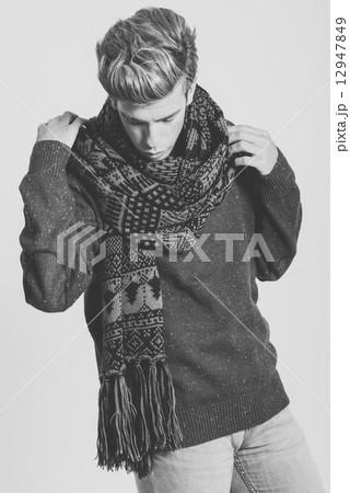 Handsome blonde man wearing sweater and scarf 12947849