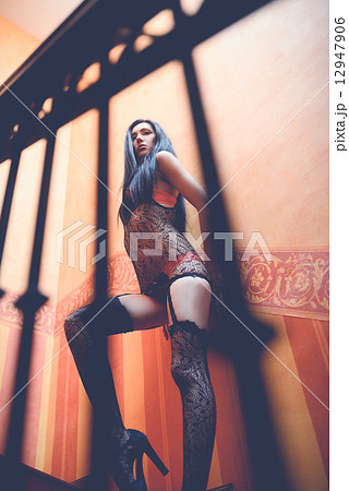 Sexy young woman in lingerie posing near wall 12947906