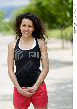 Young cheerful smiling woman in sports wear in urban background Young cheerful smiling woman in sports wear in urban background 12947983