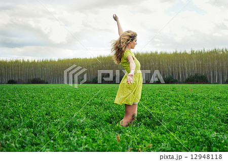 Beautiful blonde girl, dressed with a green dress, with open arm Beautiful blonde girl, dressed with a green dress, with open arm 12948118