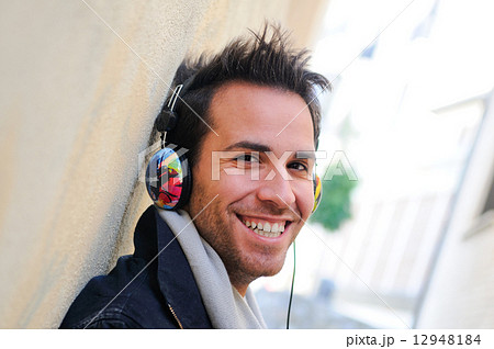 Portrait of attractive man in urban background listening to the 12948184
