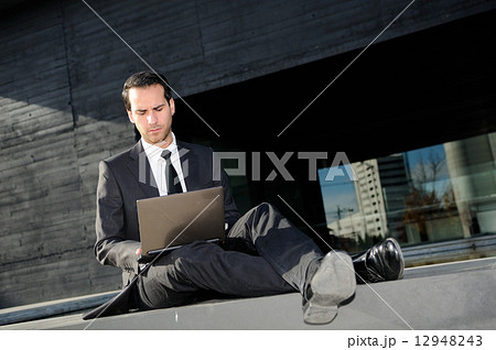 Businessman concerned about crisis typing in a laptop computer Businessman concerned about crisis typing in a laptop computer 12948243