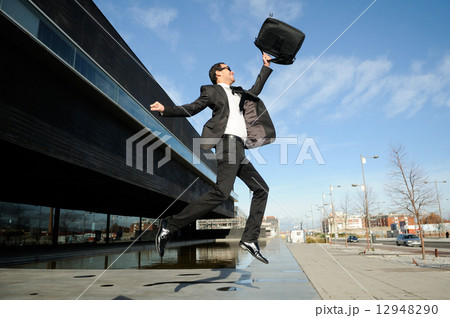 Young handsome businessman jumping in the street 12948290