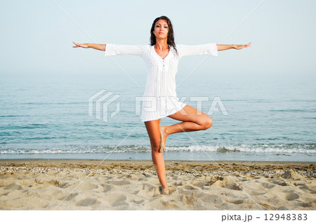 Pretty woman doing yoga on the beach Pretty woman doing yoga on the beach 12948383