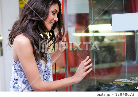 Attractive young woman looking at the shop window Attractive young woman looking at the shop window 12948672