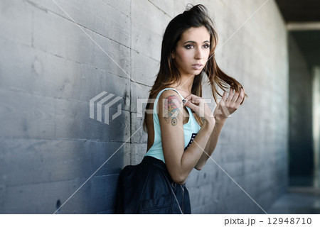 Beautiful young woman in urban background 12948710