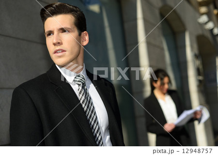 Attractive young businessmam and businesswoman in urban backgrou Attractive young businessmam and businesswoman in urban backgrou 12948757