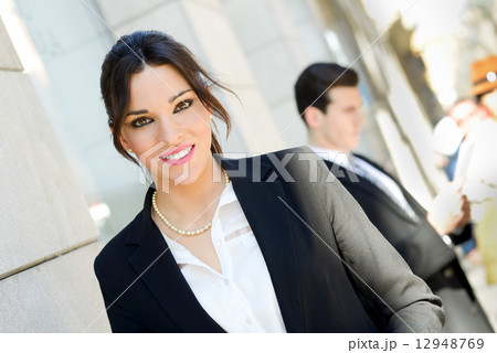 Attractive businesswoman standing outside of company building. C Attractive businesswoman standing outside of company building. C 12948769