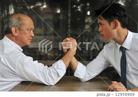 Profile of two Asian white collar men in struggle while their arms being wrestled 12950909