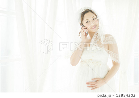 携帯電話で話す、妊娠している花嫁 12954202