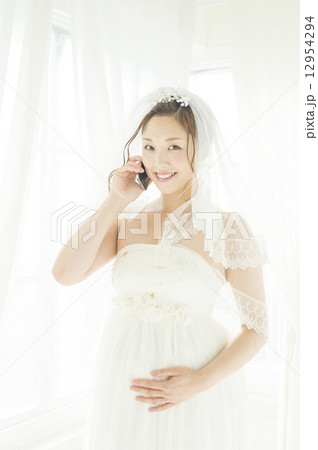 携帯電話で話す、妊娠している花嫁 12954294
