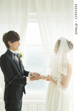 指輪交換をする新郎新婦 指輪交換をする新郎新婦 12954304