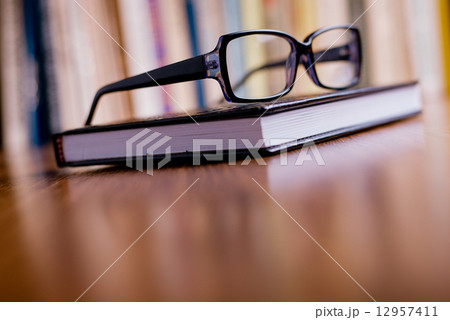 Eyeglasses on Top of the Book at the Table Eyeglasses on Top of the Book at the Table 12957411