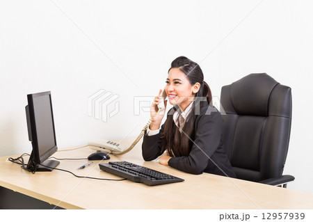 Smiling corporate business women on the phone at her office 12957939