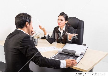 Two business people in serious discussion Two business people in serious discussion 12958052