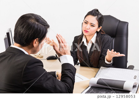 Two business people in serious discussion Two business people in serious discussion 12958053