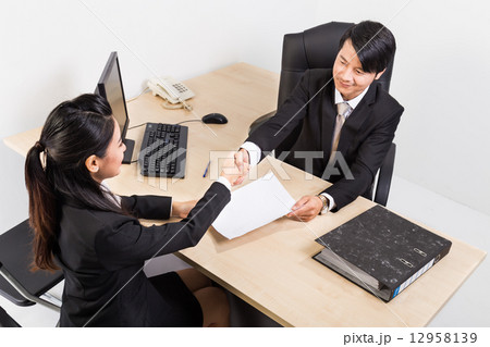 Two business people shaking hand at an office 12958139