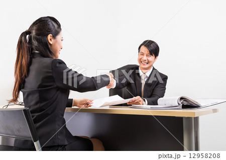 Two business people shaking hand at an office Two business people shaking hand at an office 12958208