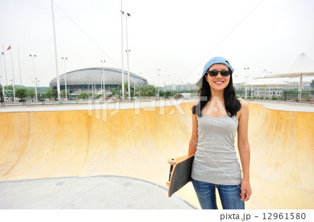 young woman skateboarder walking at skatepark young woman skateboarder walking at skatepark 12961580