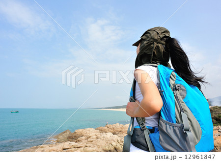 hiking woman stand seaside rock looking at the view  12961847