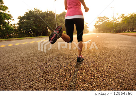 young fitness woman running at sunrise road 12964266