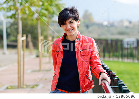 Woman with short hair wearing red jacket 12965696