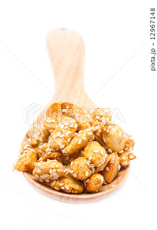 Crispy sugared nuts with wooden spoon isolated on white. Crispy sugared nuts with wooden spoon isolated on white. 12967148