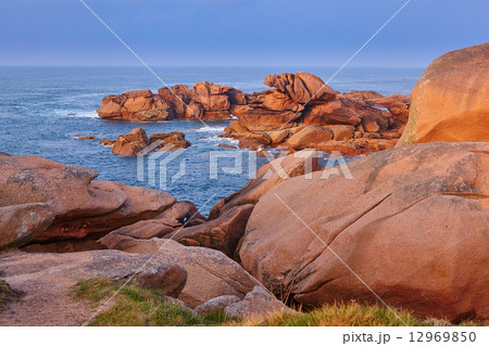 Scenic view of pink granite coast at sunset 12969850