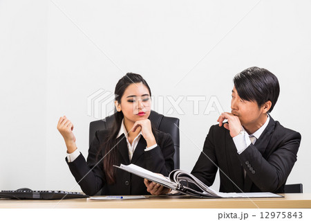 Two confident business people in the office discussing Two confident business people in the office discussing 12975843