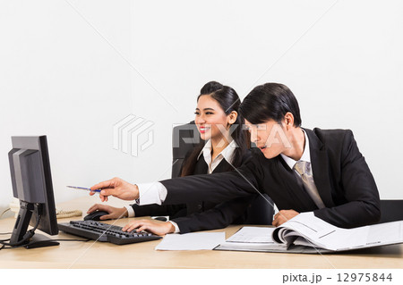 Two confident business people in the office discussing Two confident business people in the office discussing 12975844