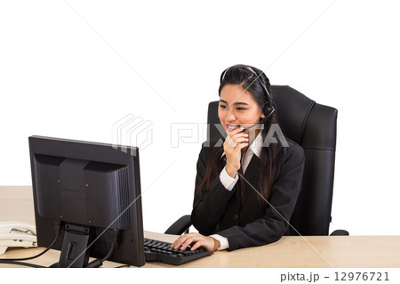 Friendly call center operator working at her work station 12976721