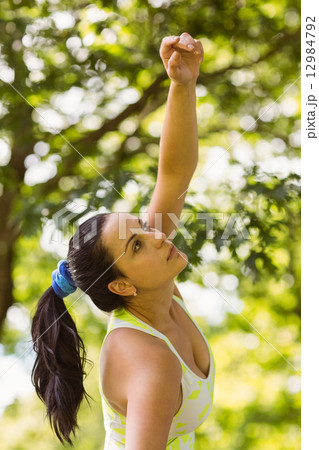 Concentrated fit brunette stretching in the park Concentrated fit brunette stretching in the park 12984792