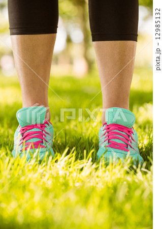 Woman in running shoes standing on grass 12985132