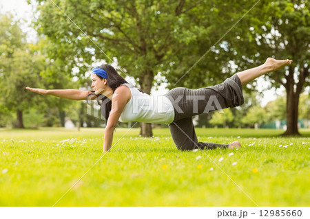 Brunette in balance pose on grass Brunette in balance pose on grass 12985660