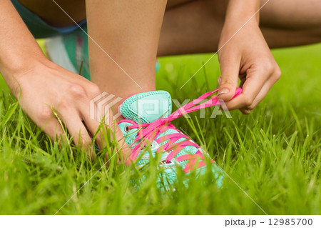 Fit woman tying her shoelace 12985700