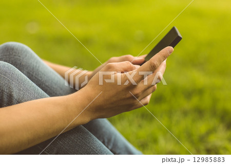 Mid section of a pretty redhead with her mobile phone Mid section of a pretty redhead with her mobile phone 12985883