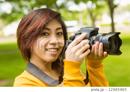 Beautiful female photographer at park 12985965
