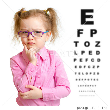 Serious girl in glasses with eye chart isolated 12989178