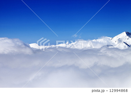 Mountains under clouds in sun day Mountains under clouds in sun day 12994868