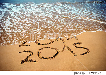 New Year 2015 is coming concept - inscription 2014 and 2015 on a beach sand, the wave is covering di New Year 2015 is coming concept - inscription 2014 and 2015 on a beach sand, the wave is covering di 12995246
