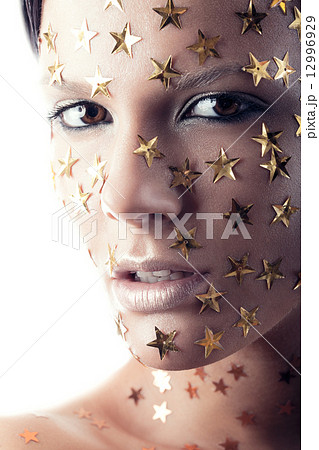 Close up woman portrait with stars on face 12996929