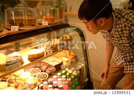 Man choosing desserts at a cafe 12999531
