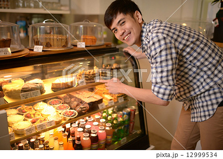Man choosing desserts at a cafe Man choosing desserts at a cafe 12999534