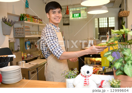 Cafe staff at the cashier 12999604