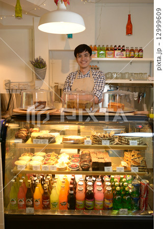 Cafe staff at the cashier 12999609