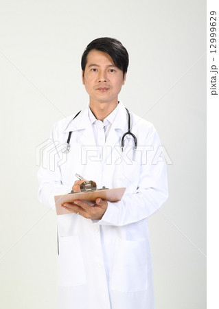 Male Doctor MD looking forward holding clipboard Male Doctor MD looking forward holding clipboard 12999629
