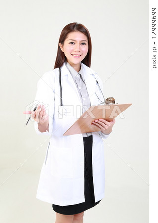 Lady Doctor Holding Clipboard and Pen Looking forward Lady Doctor Holding Clipboard and Pen Looking forward 12999699
